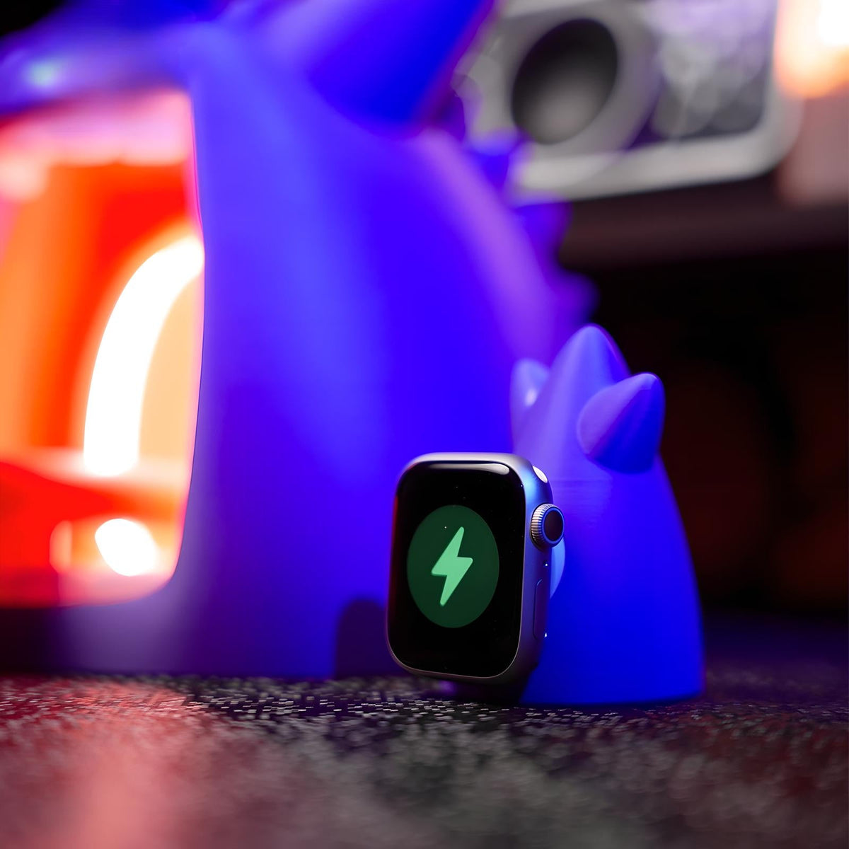 Gengar-themed wireless charging stand with embedded smartwatch charger, glowing ambient purple lighting, anime-inspired desk accessory for Apple Watch charging display
