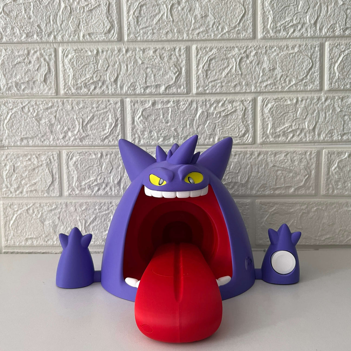 Gengar-inspired wireless charger on desk with LED light off, purple figure design, front view