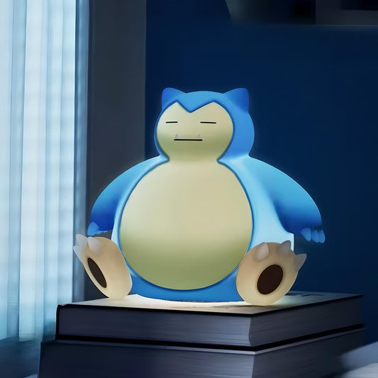 Snorlax-inspired bedside night lamp glowing on stacked books near window, soft warm light