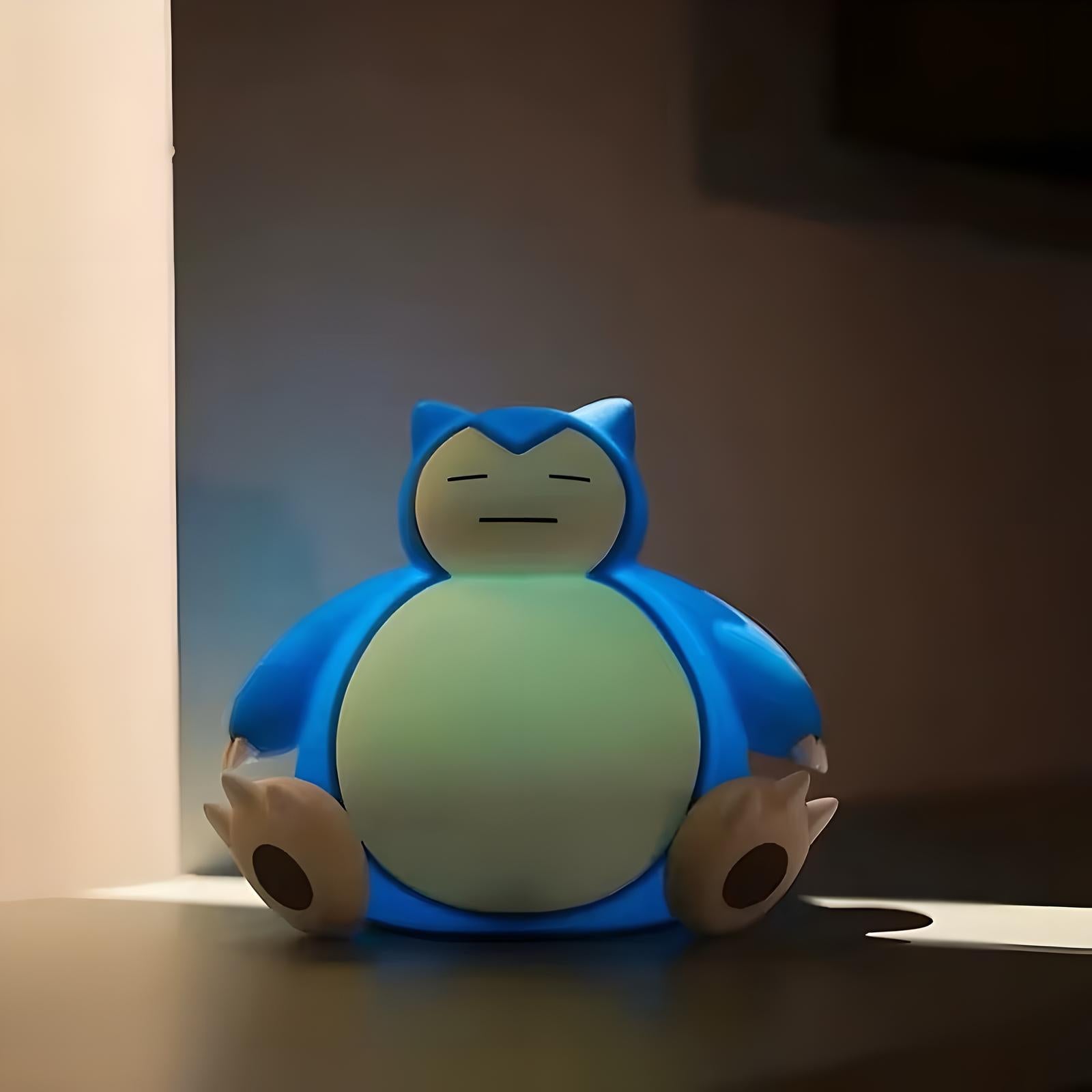 Snorlax-inspired LED night light on desk beside computer monitor, soft ambient bedtime lighting