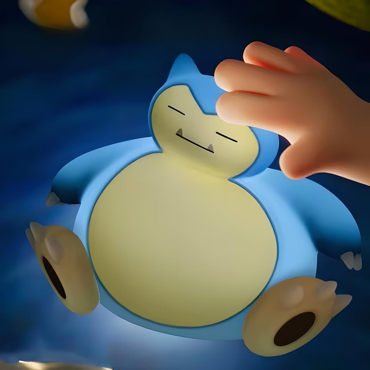 Hand tapping Snorlax-inspired silicone night light to adjust brightness, cozy warm glow in bedroom