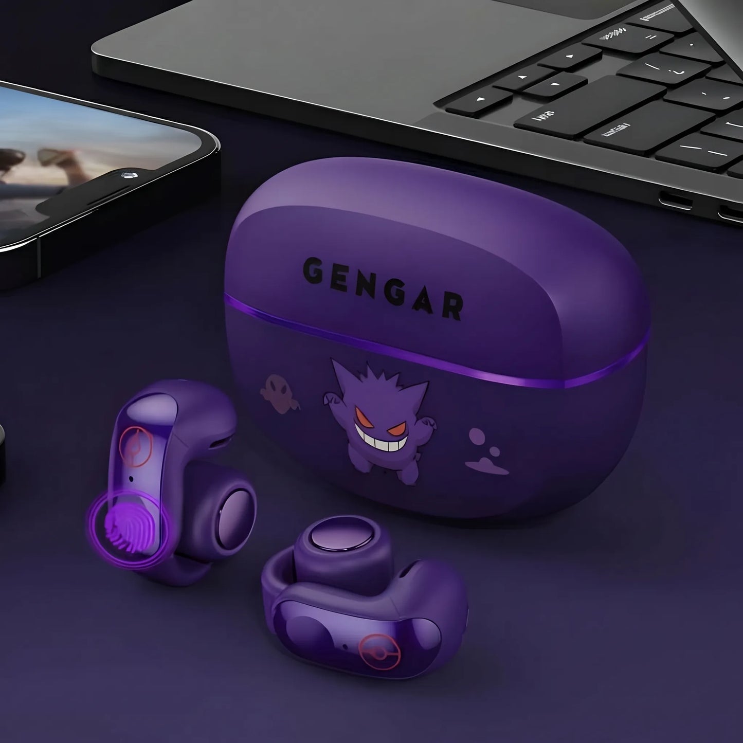 Gengar purple open-ear wireless earbuds with charging case on desk beside laptop and phone