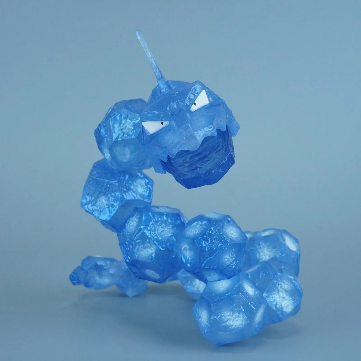 Translucent blue Onix-inspired rock serpent toothbrush holder figurine, close-up product photo